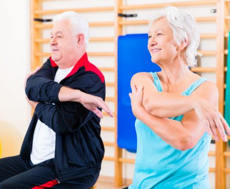 Senior people in fitness exercise doing gymnastic stretching